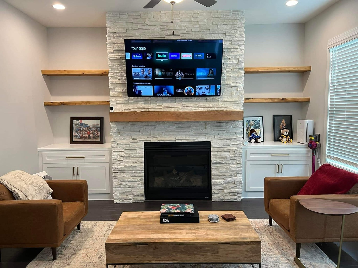 Floating shelves flanking a stone fireplace